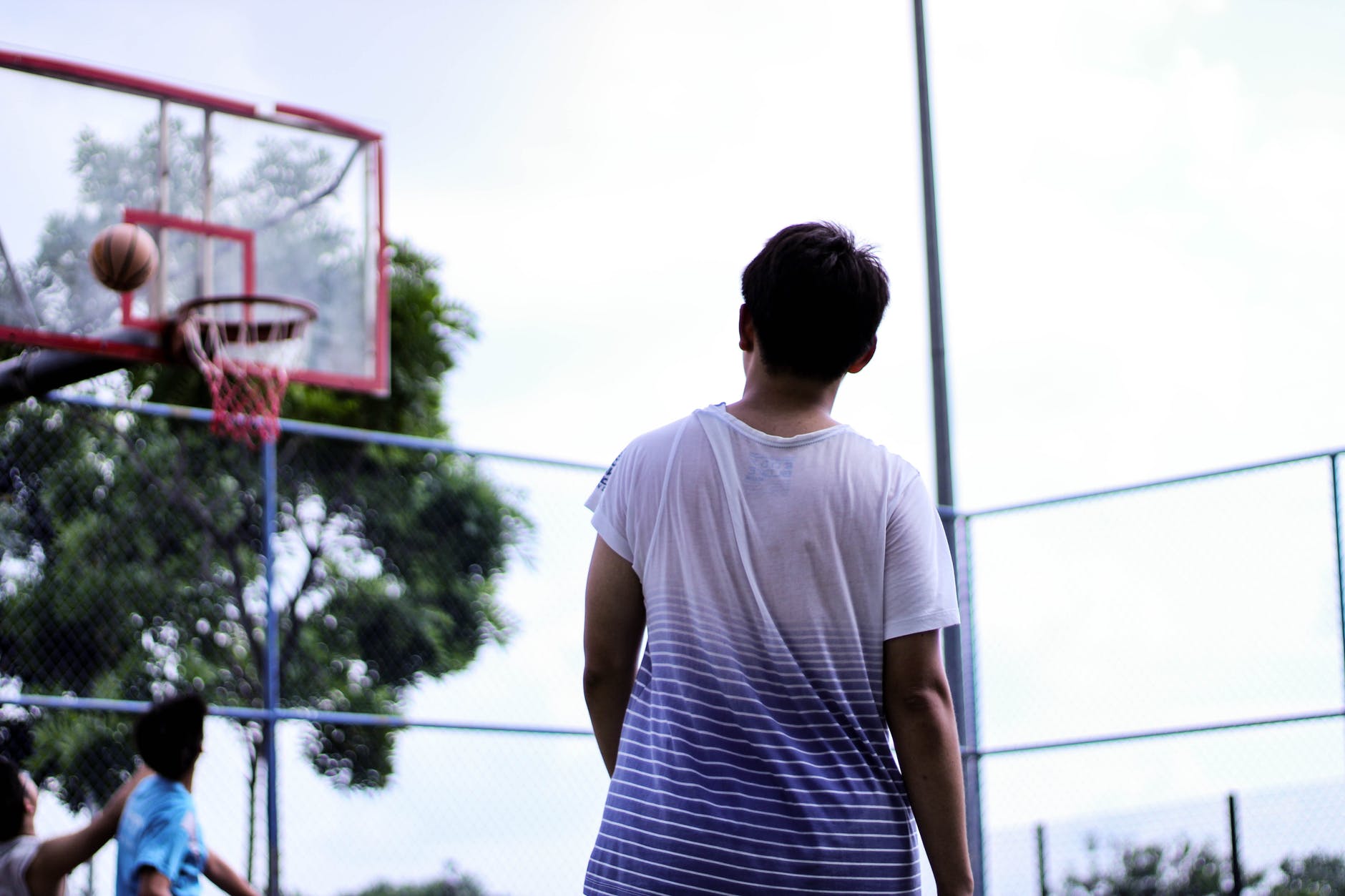 man standing near red basketball hoop system