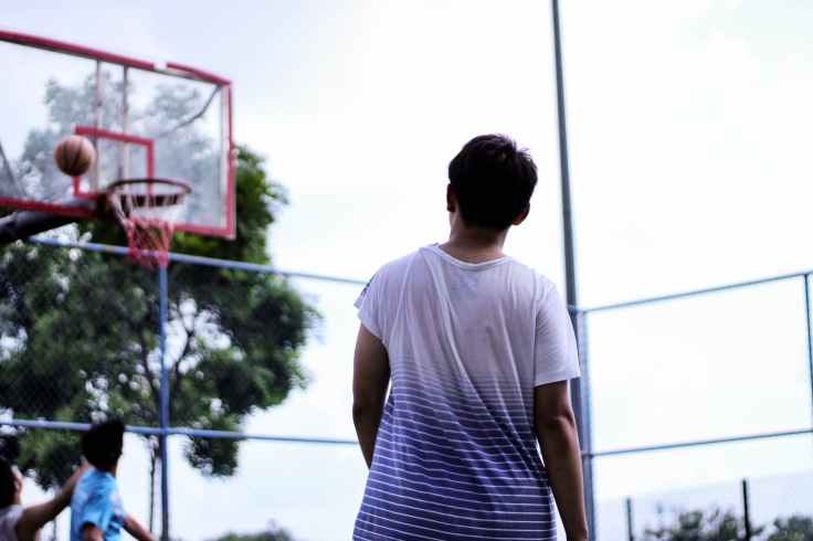 man standing near red basketball hoop system